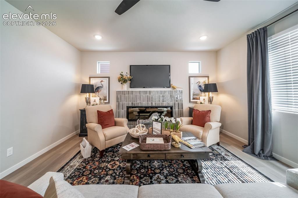 Image 21 of 45: Living area featuring a tiled fireplace with mantel, recessed lighting, and