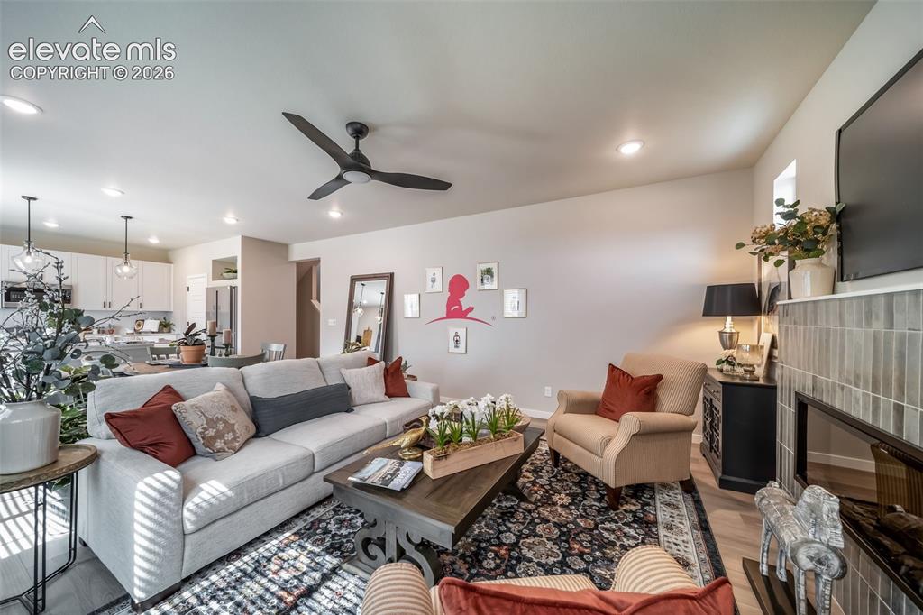 Image 23 of 45: Living area featuring a ceiling fan, recessed lighting, and wood-finish flo