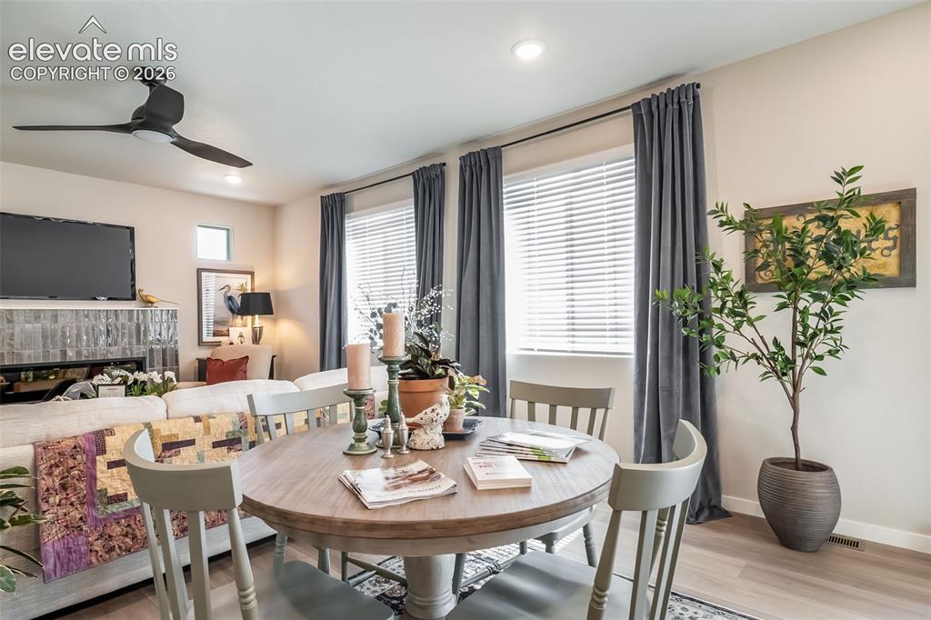 Image 25 of 45: Open-concept living area featuring a central dining space with wood-finish