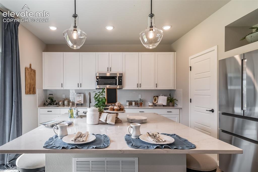 Image 27 of 45: Kitchen featuring a large central island with a light-colored countertop
*