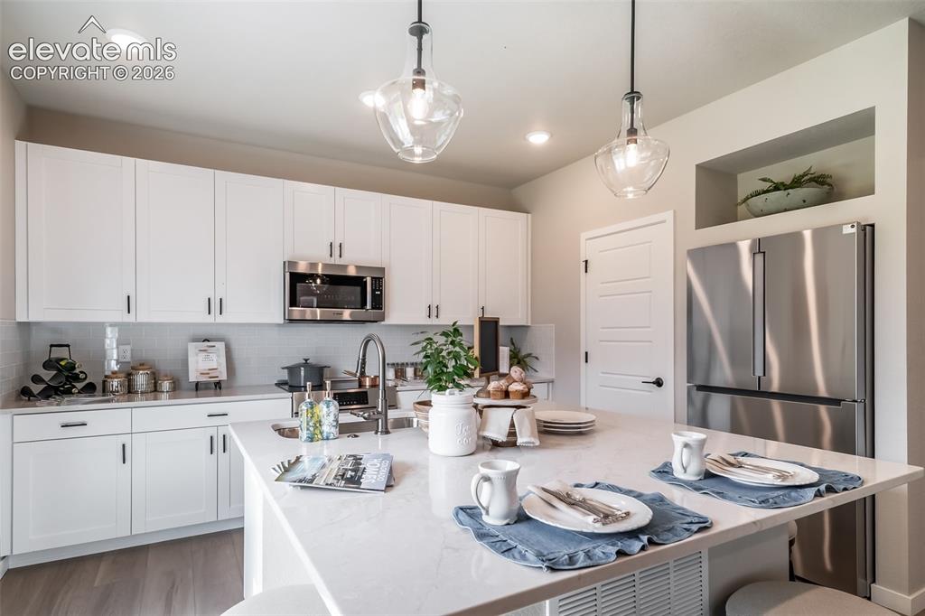 Image 28 of 45: Gourmet kitchen featuring a large island with seating, stainless steel appl