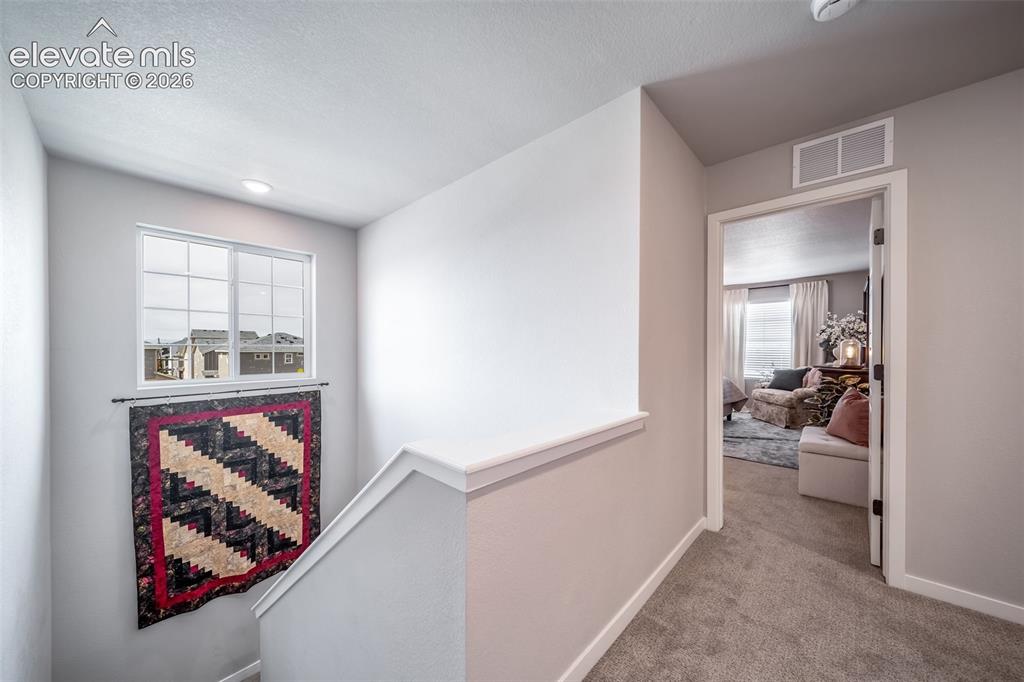 Image 34 of 45: Upper-level hallway with neutral wall finishes and carpeted flooring
*Phot