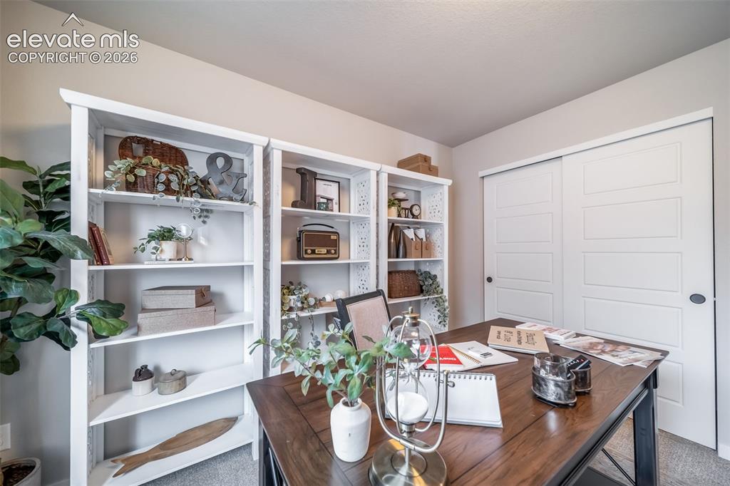 Image 7 of 45: Dedicated workspace featuring multiple built-in shelving units, a large woo
