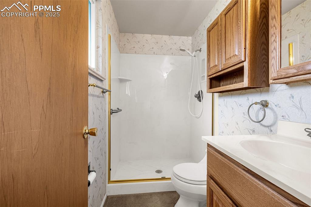 Image 13 of 19: Three piece bathroom in master bedroom including stall shower, sink & toile