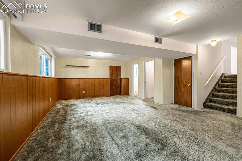 Image 14 of 19: Spacious lower level family room featuring laundry room, half-bathroom and 