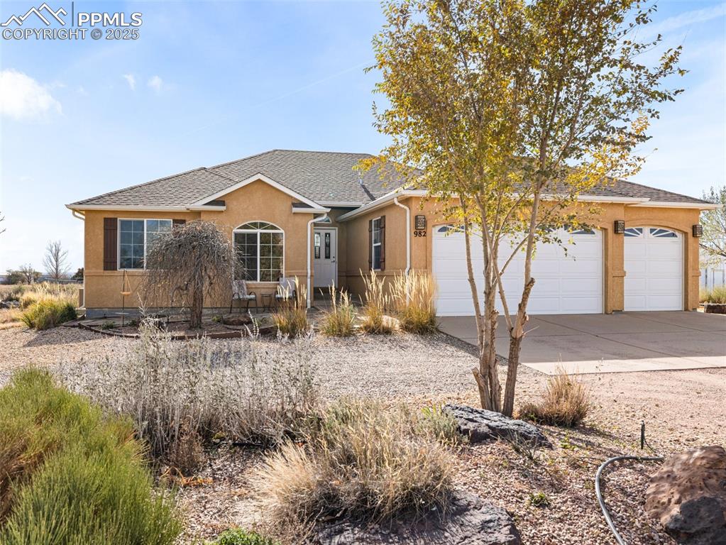 Caption: Ranch-style home with driveway, stucco siding, roof with shingles, and a garage
