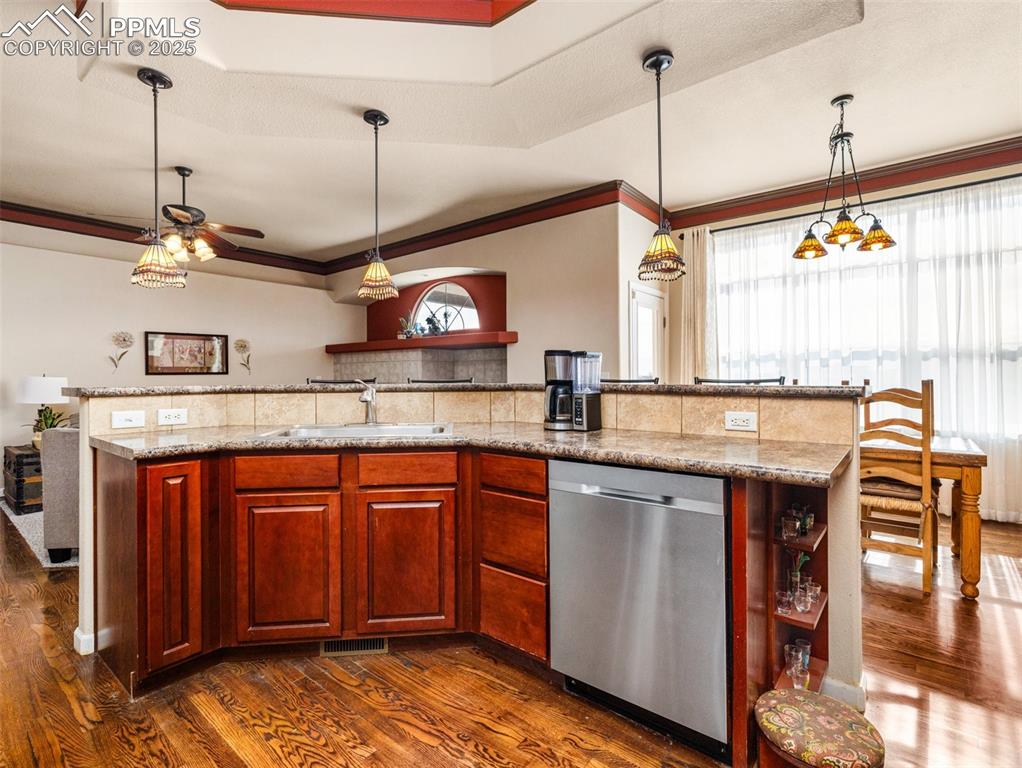 Image 10 of 48: Kitchen with pendant lighting, dark wood-style floors, stainless steel dish