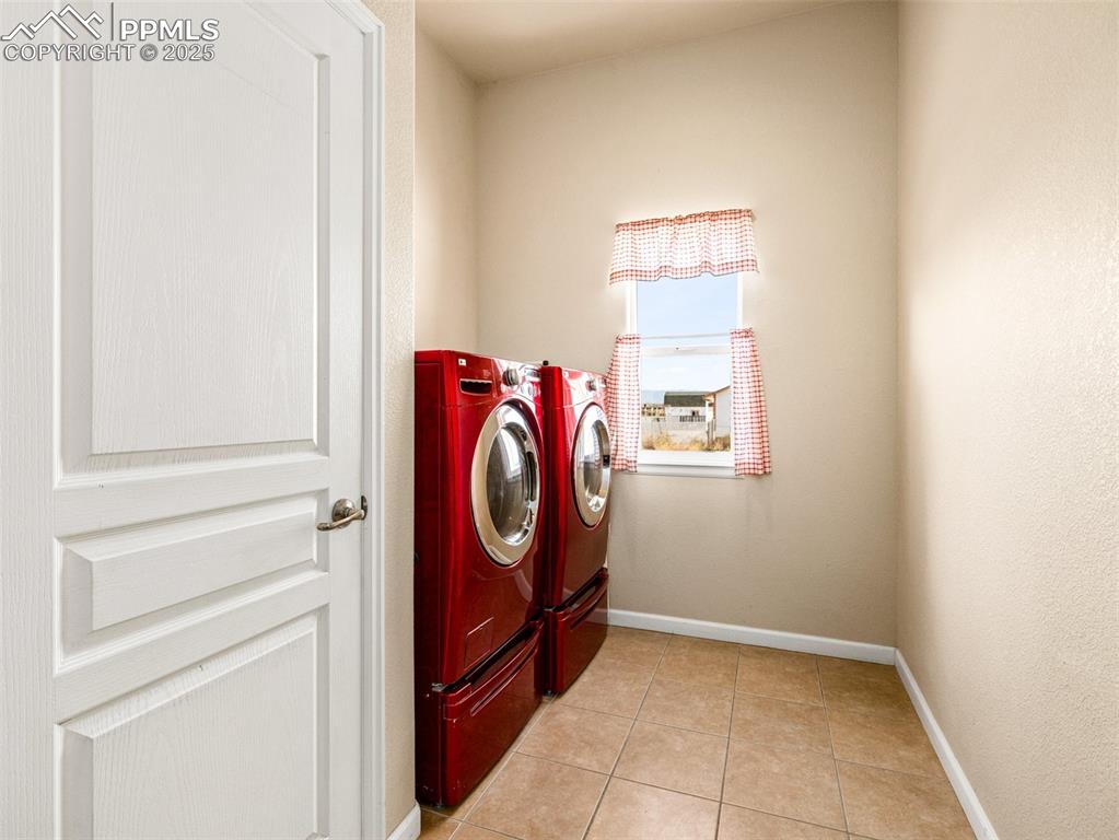 Image 13 of 48: Laundry room featuring light tile patterned floors and separate washer and 