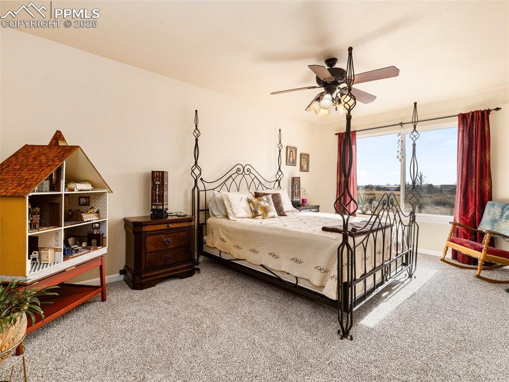Image 15 of 48: Bedroom with light colored carpet and a ceiling fan