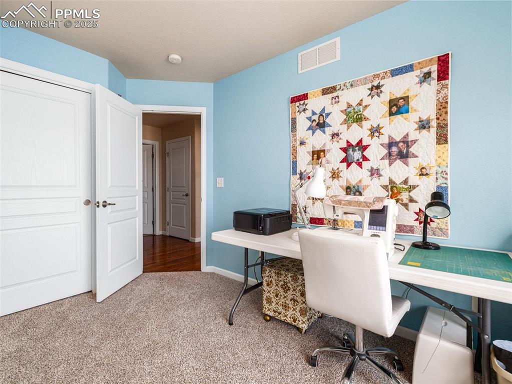 Image 21 of 48: Home office with carpet floors and baseboards