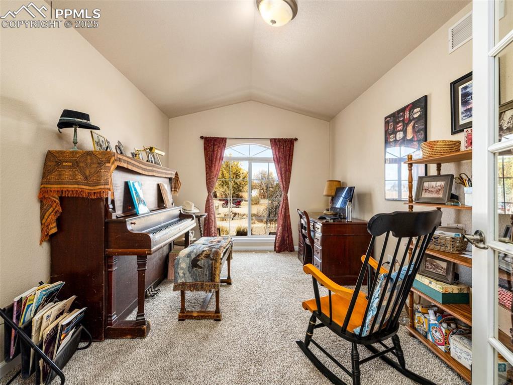 Image 22 of 48: Office featuring lofted ceiling and light carpet