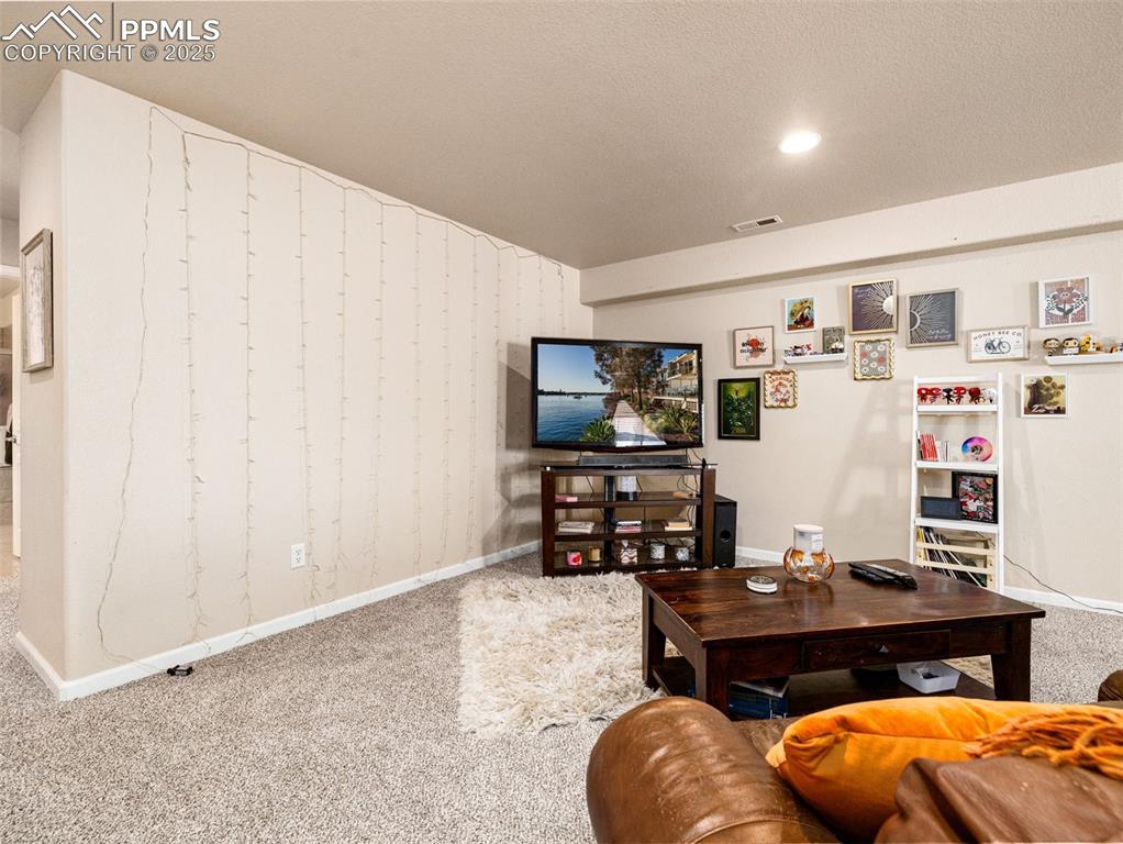 Image 27 of 48: Living area with carpet, wallpapered walls, recessed lighting, and a textur