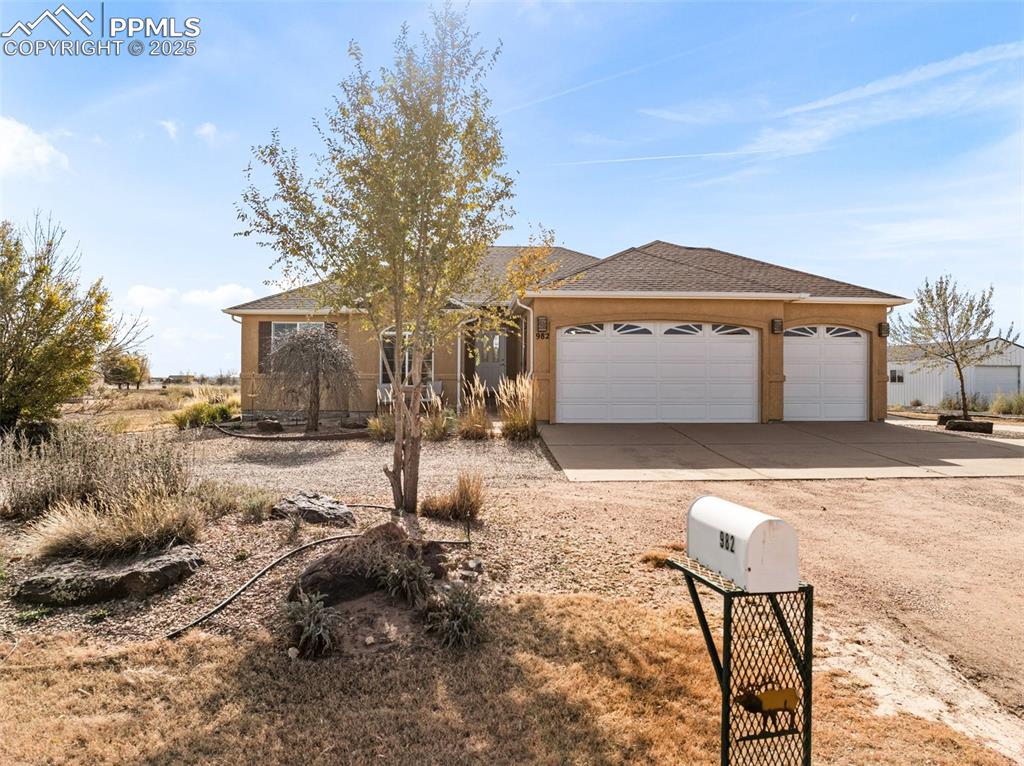 Image 35 of 48: Ranch-style home with driveway, a shingled roof, a garage, and stucco sidin