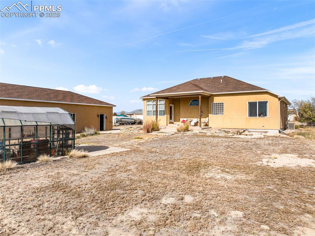 Image 42 of 48: Rear view of property featuring stucco siding, a patio area, and roof with 