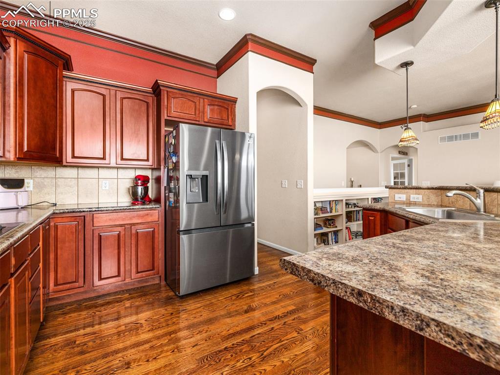 Image 9 of 48: Kitchen with tasteful backsplash, stainless steel refrigerator with ice dis