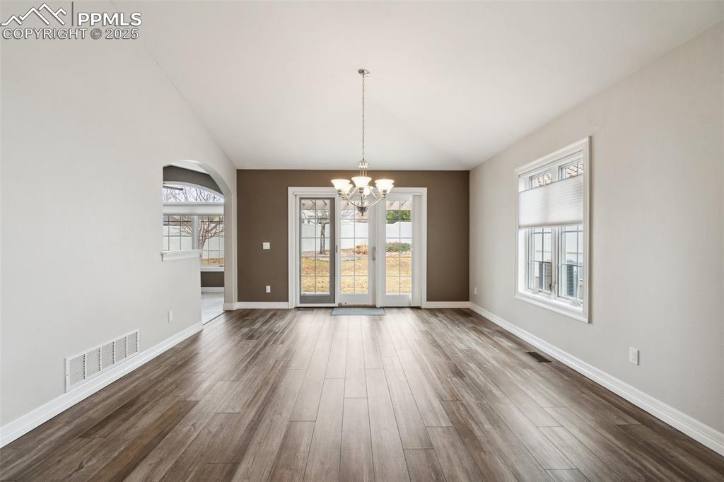Image 10 of 49: Unfurnished dining area with baseboards, visible vents, a notable chandelie