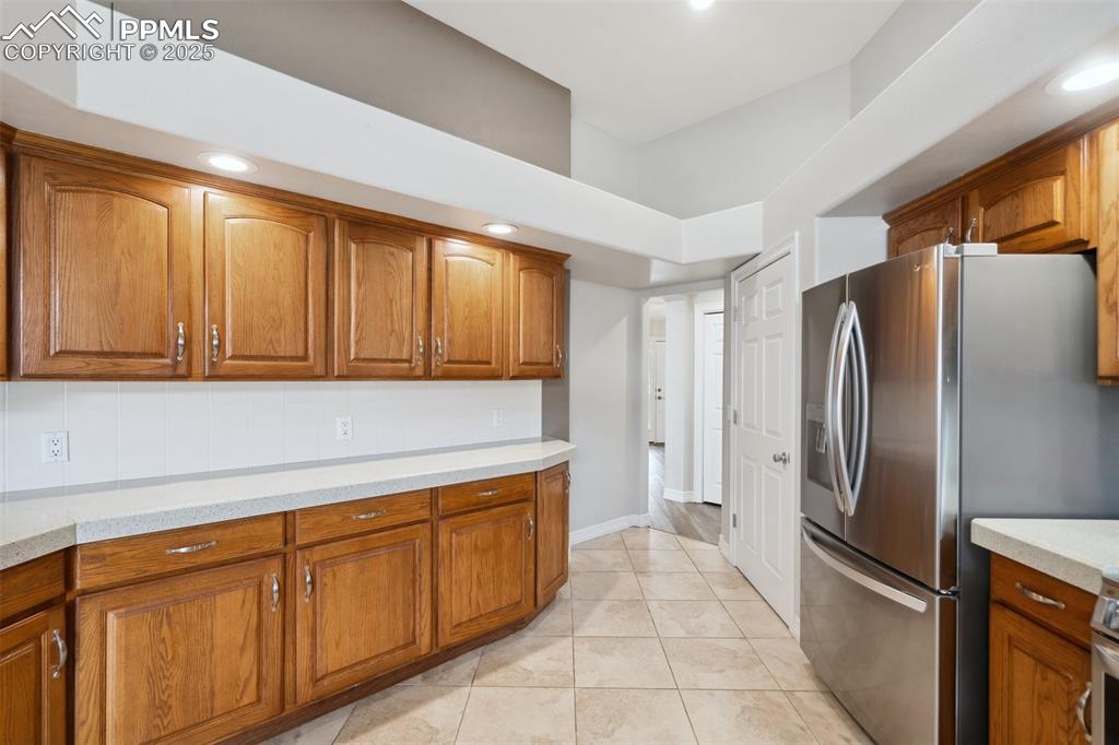 Image 13 of 49: Kitchen featuring recessed lighting, decorative backsplash, light tile patt