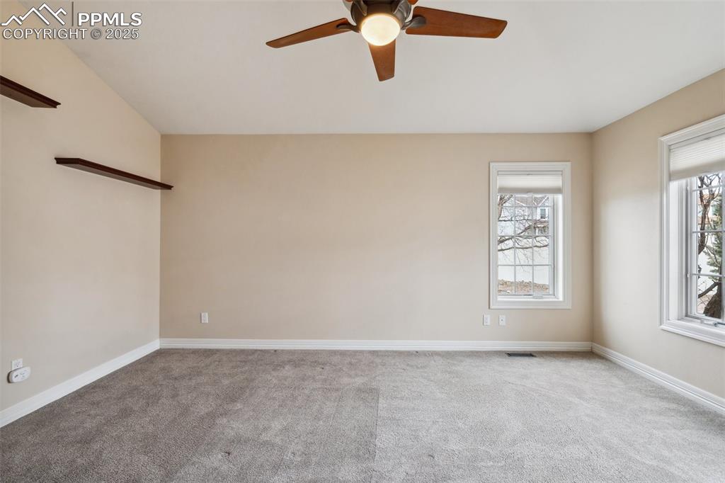 Image 17 of 49: Carpeted empty room featuring baseboards, visible vents, and a ceiling fan