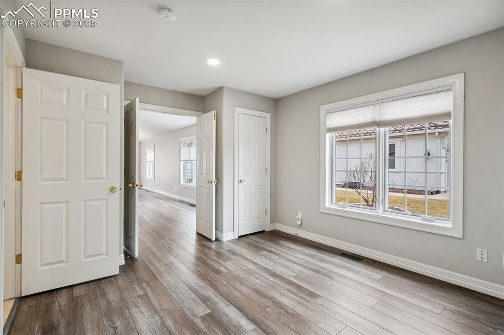 Image 22 of 49: Unfurnished bedroom with baseboards, visible vents, and wood finished floor