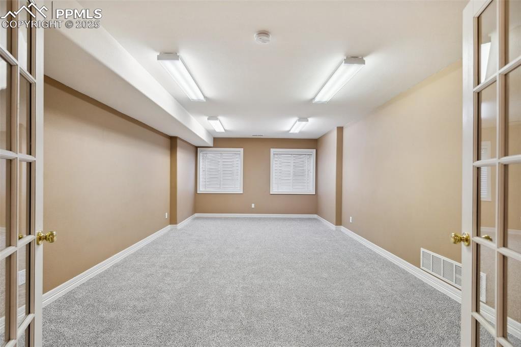 Image 27 of 49: Spare room with french doors, carpet, baseboards, and visible vents