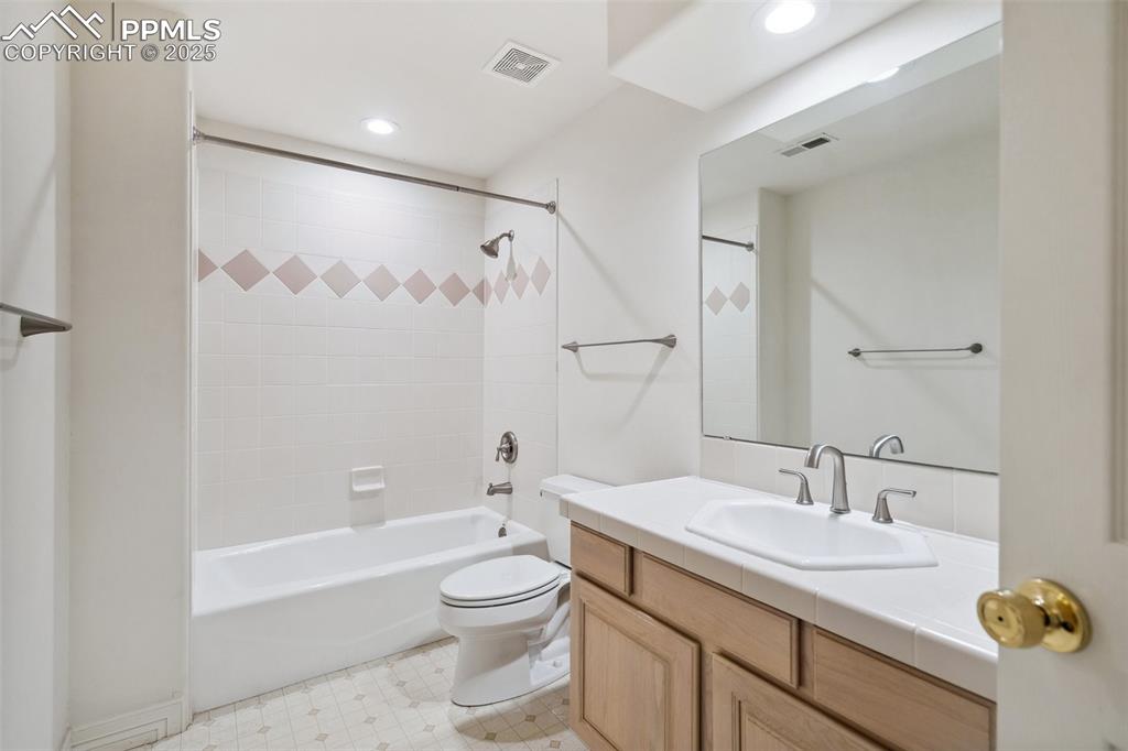 Image 28 of 49: Bathroom with toilet, vanity, recessed lighting, and visible vents