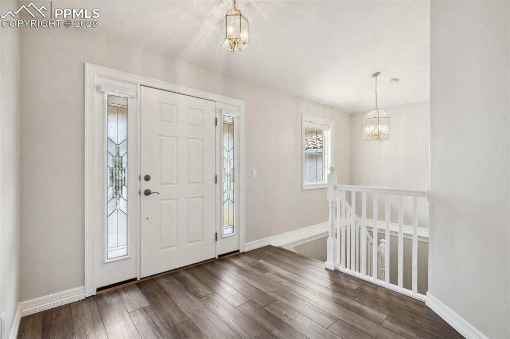 Image 3 of 49: Foyer featuring an inviting chandelier, baseboards, and wood finished floor