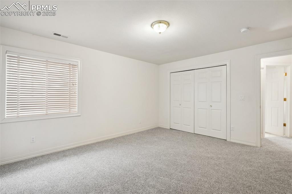 Image 30 of 49: Unfurnished bedroom featuring baseboards, visible vents, a closet, and carp