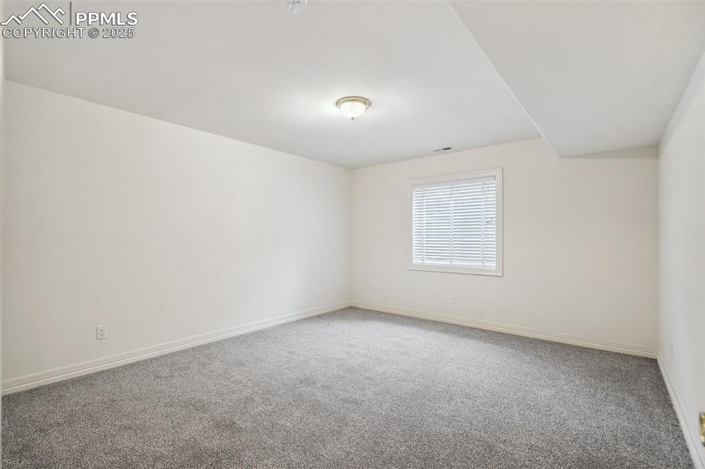 Image 32 of 49: Carpeted spare room with baseboards