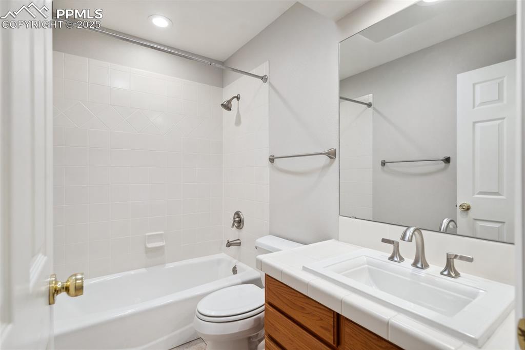 Image 33 of 49: Bathroom with toilet, vanity, washtub / shower combination, and recessed li