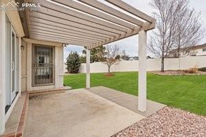 Image 34 of 49: Fenced backyard featuring a patio