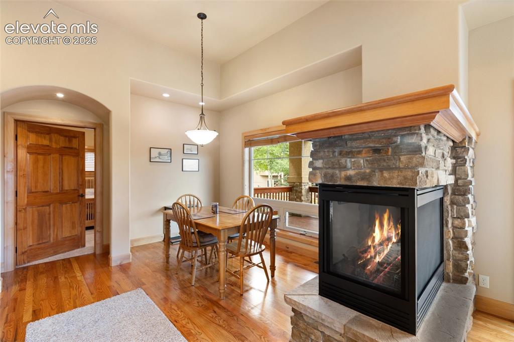 Image 5 of 24: Dining room with tri-sided gas fireplace.