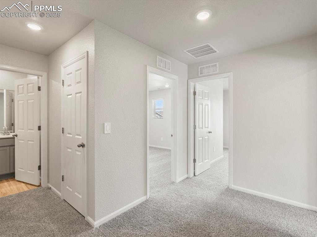 Image 14 of 30: Hall featuring light colored carpet and baseboards