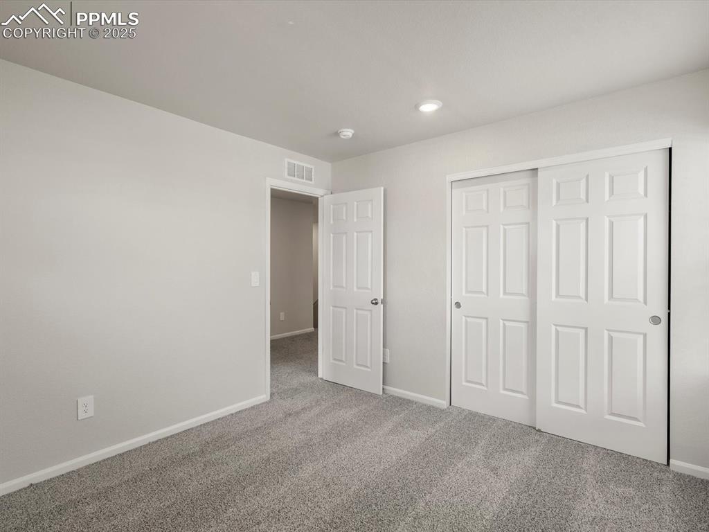 Image 20 of 30: Unfurnished bedroom with carpet flooring, a closet, and recessed lighting