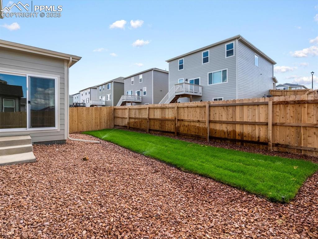 Image 8 of 30: Fenced backyard with a residential view