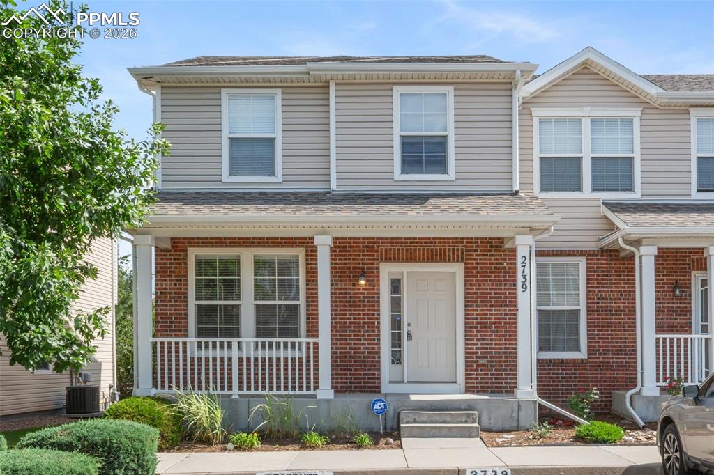 Image 1 of 38: Traditional-style house featuring brick siding and a shingled roof