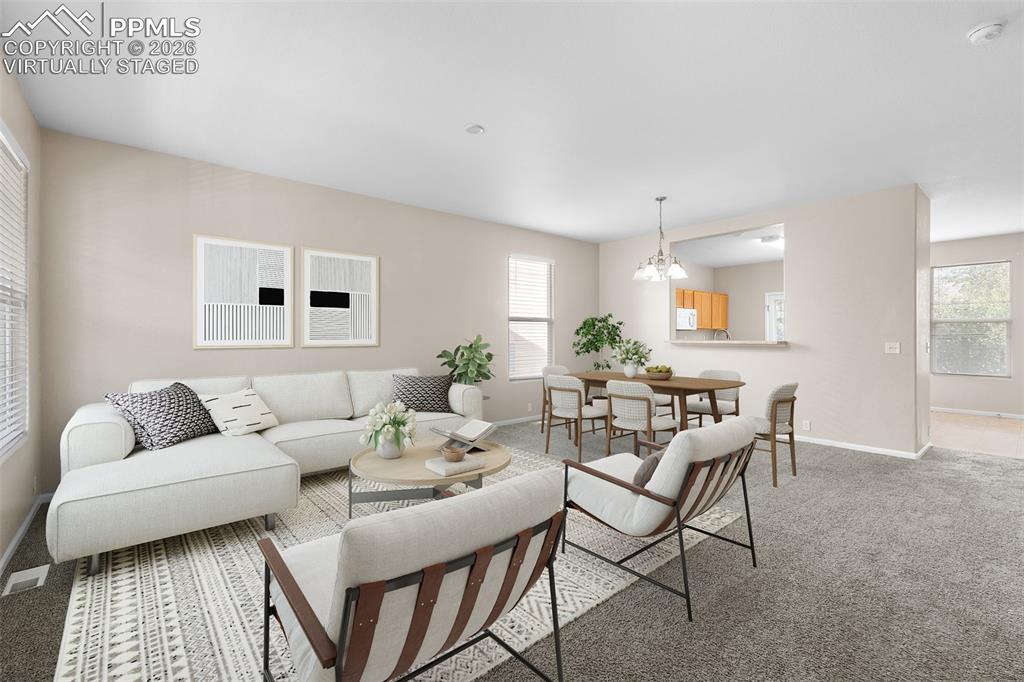Image 12 of 38: *Virtually Staged* Living room featuring light carpet and a chandelier