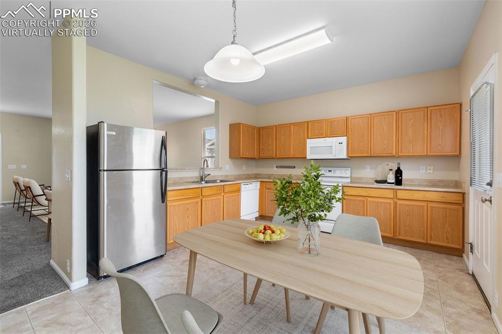 Image 14 of 38: *Virtually Staged* Kitchen featuring white appliances, light countertops, d