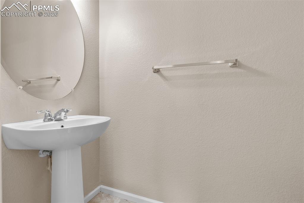 Image 20 of 38: Main Level Half Bath with baseboards and a textured wall