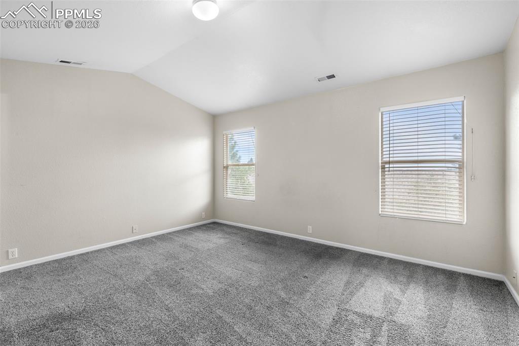 Image 24 of 38: Carpeted spare room featuring baseboards and lofted ceiling