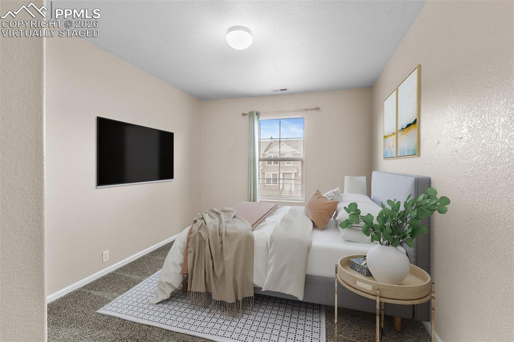 Image 26 of 38: *Virtually Staged* Bedroom featuring a textured wall and carpet floors