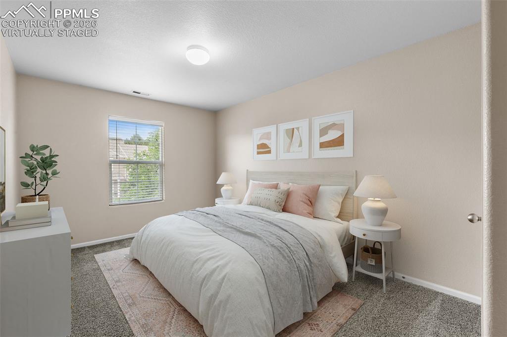 Image 28 of 38: *Virtually Staged* Bedroom with light carpet and a textured ceiling