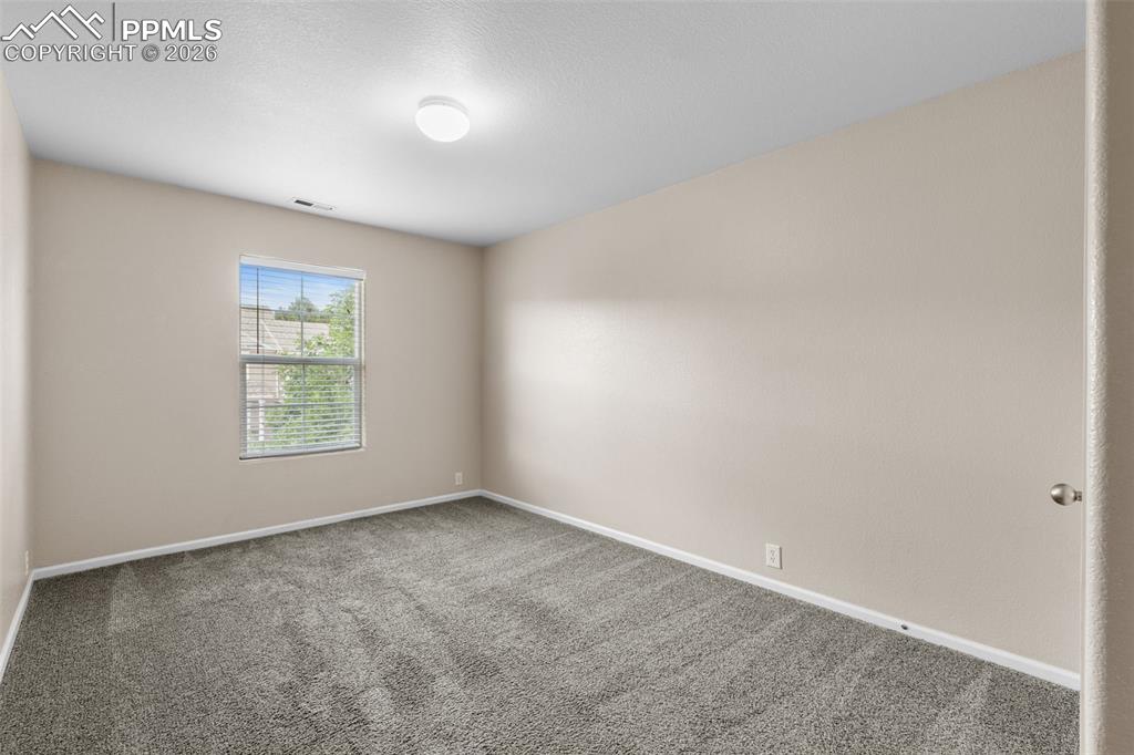 Image 29 of 38: Empty room with carpet floors and a textured ceiling