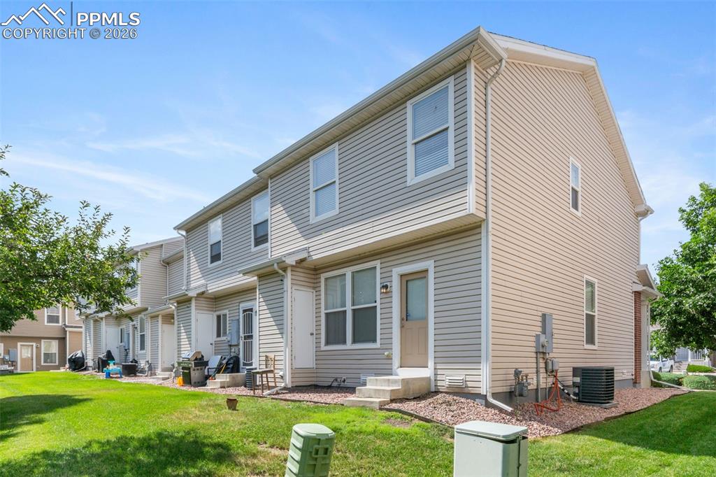 Image 31 of 38: Rear view of property featuring a yard and entry steps