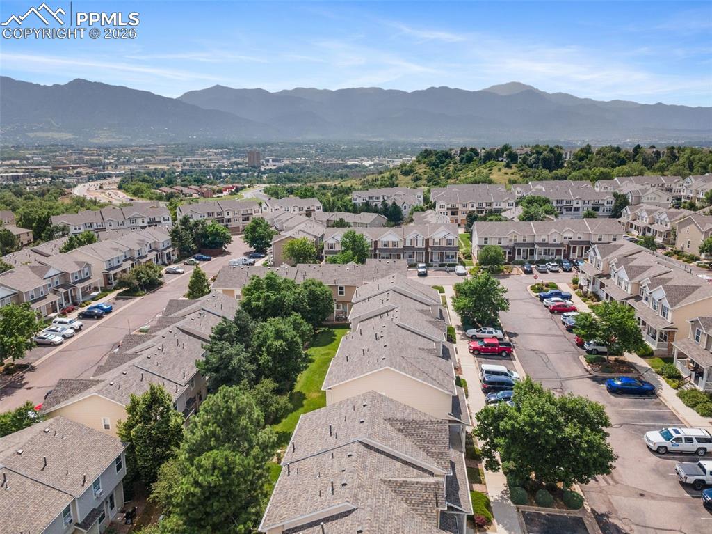 Image 35 of 38: Aerial view of residential area featuring a mountainous background