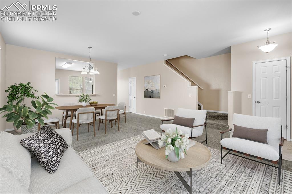 Image 8 of 38: *Virtually Staged* Living room featuring stairs, carpet, and a chandelier