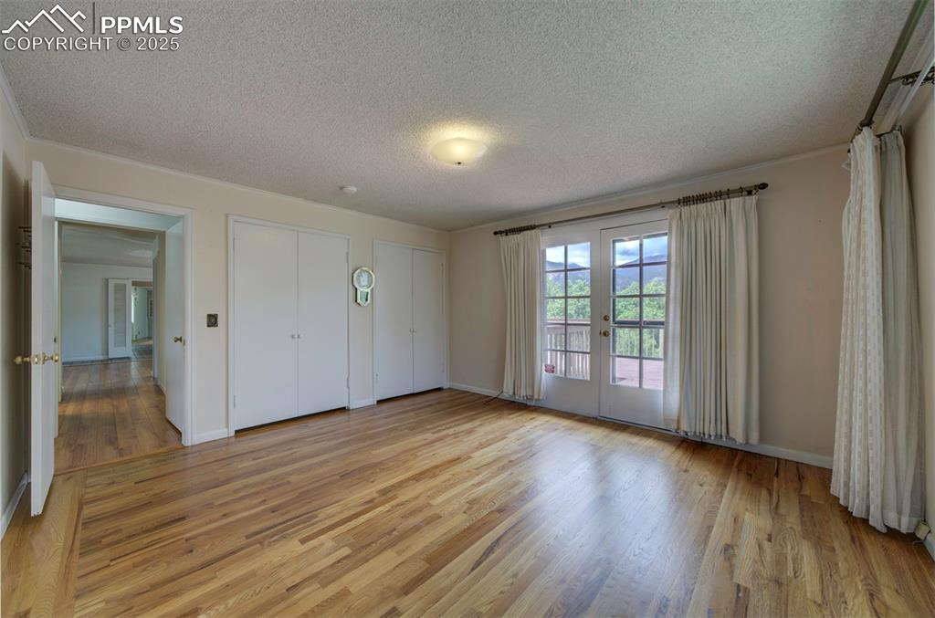Image 21 of 49: Unfurnished bedroom featuring two closets, light wood-type flooring, a text