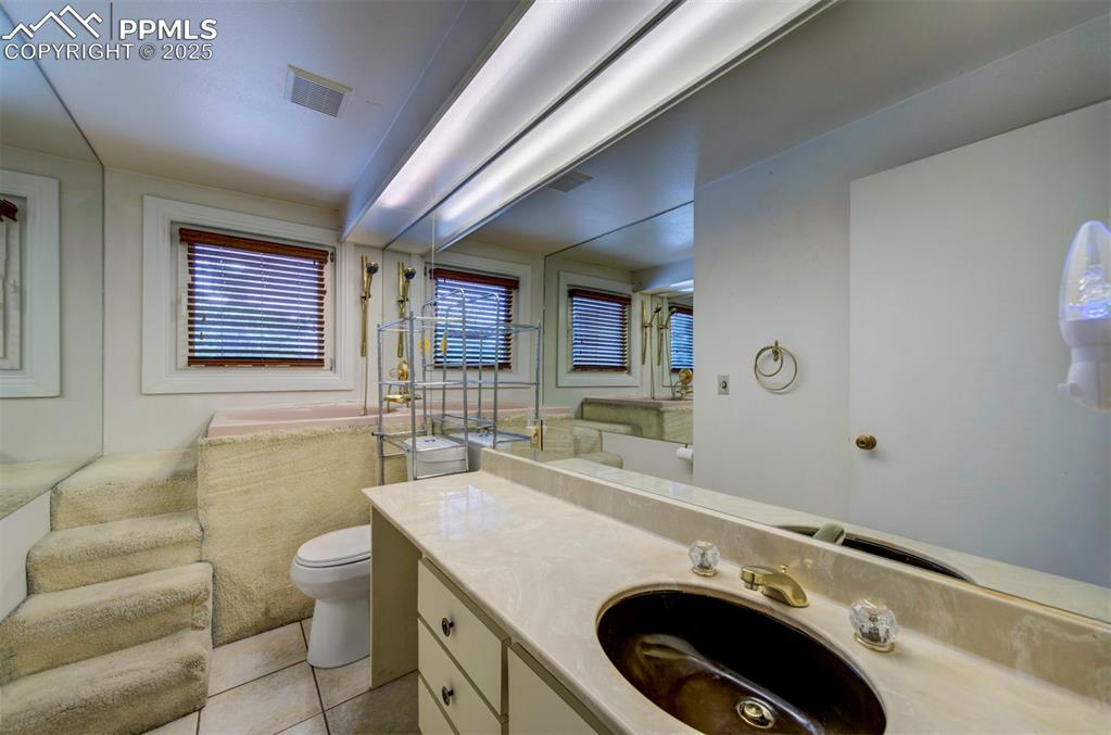 Image 22 of 49: Bathroom featuring toilet, tile patterned flooring, and vanity