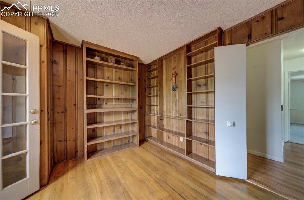 Image 31 of 49: Empty room featuring light wood-style flooring, a textured ceiling, wooden