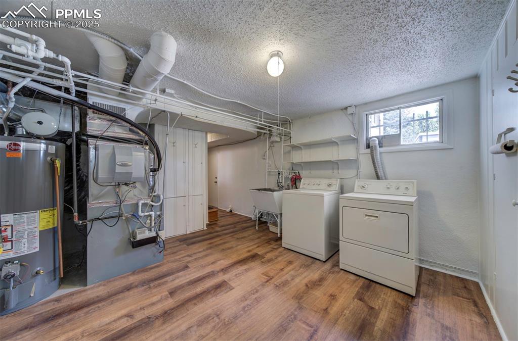 Image 38 of 49: Laundry room featuring washing machine and clothes dryer, gas water heater,