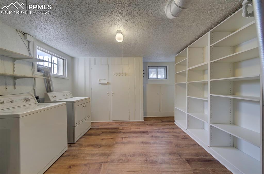 Image 41 of 49: Laundry room with washer and dryer, a textured ceiling, dark wood finished